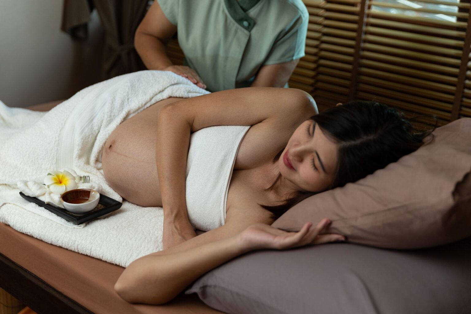 two people showing pregnancy massage technique